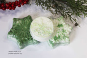 Snowflake-shaped bath bombs with green and white colors on a white background with Christmas decorations.by Vermont Lavender