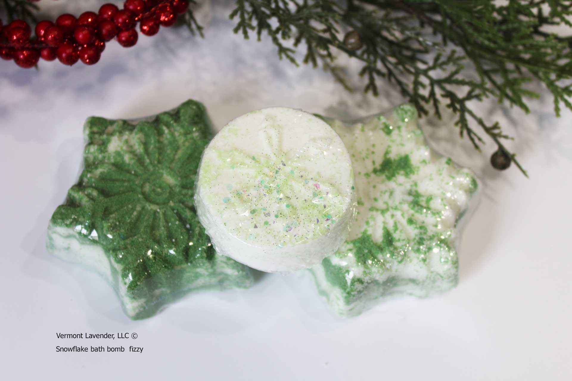 Snowflake-shaped bath bombs with green and white colors on a white background with Christmas decorations.by Vermont Lavender
